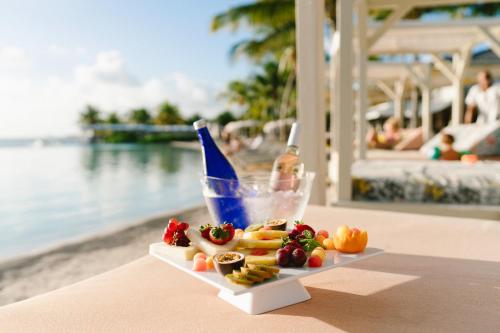 a plate of fruit and a drink on a table near the water at Papagayo Beach Hotel in Willemstad