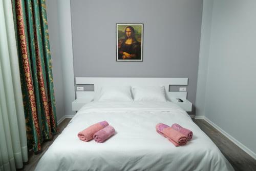 una cama con dos manoplas rosas sentadas en ella en Travelers' Korça Home, en Korçë