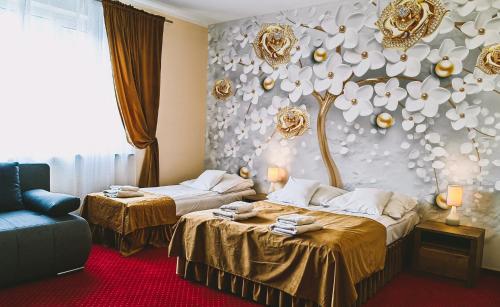 a hotel room with two beds and a tree on the wall at Rezydencja Królewska in Sandomierz