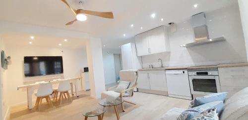 a kitchen with white cabinets and a table and chairs at Tarragonaapartments Prim 350 in Reus