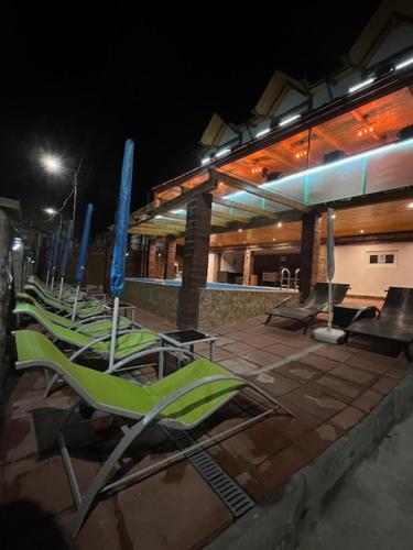 a row of chairs sitting outside of a building at night at Gasthaus Casa Kugler in Anina