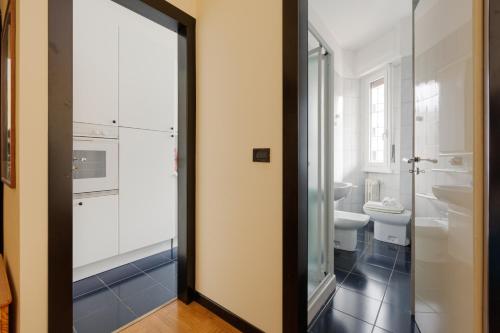 a bathroom with a toilet and a glass door at Forlanini - Functional Studio with Balcony! in Milan