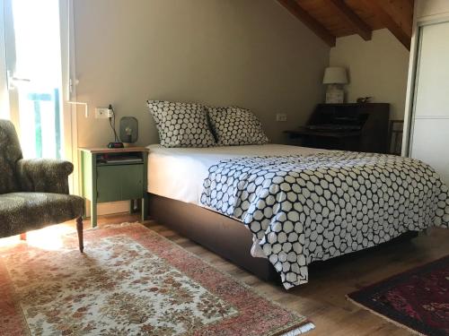 a bedroom with a bed and a chair at Appartement à côté de la plage avec piscine climatisé in Hendaye