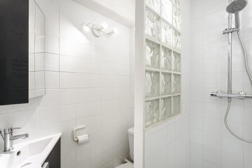 a white bathroom with a shower and a sink at Vue et face Golf Port Bourgenay in Talmont-Saint-Hilaire