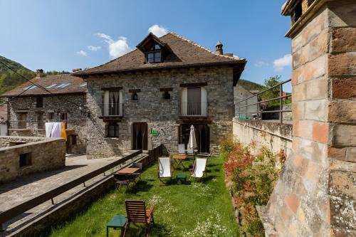 an old stone house with chairs and a yard at Casa Tadeguaz in Fago