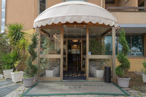 wejście do hotelu z roślinami przed nim w obiekcie Hotel Santa Maura w Rzymie