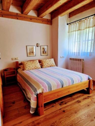 a bedroom with a bed with a wooden floor at Casa Tadeguaz in Fago