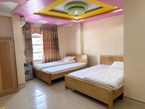 twee bedden in een kamer met een plafond bij TIẾN CƯỜNG HOTEL in Mia Xu
