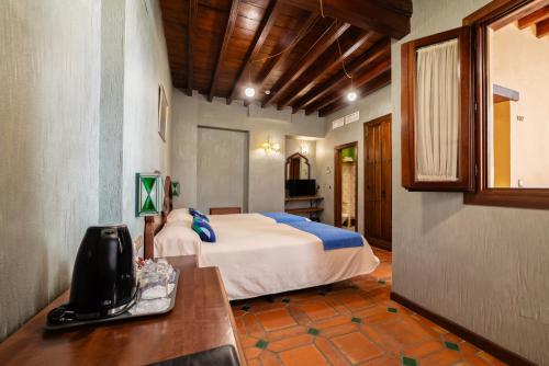 a bedroom with a bed and a desk in a room at Hotel Posada del Toro in Granada