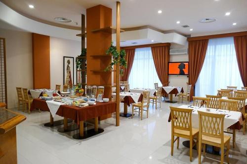 Un comedor con mesas y sillas y ventanas. en STELLA CHARMING & LUXURY ROOMS, en Conversano