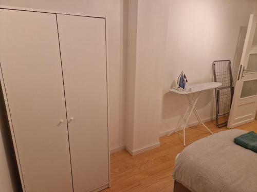 a bedroom with a white cabinet next to a bed at Bright and cozy room next to the airport petit in Kampenhout