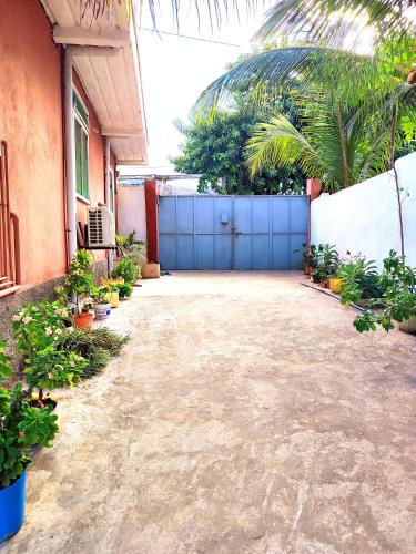 a garage with a blue gate and some plants at VILLA KIMRAN in Mahajanga