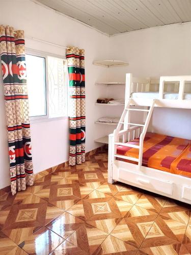 a bedroom with two bunk beds and a wooden floor at VILLA KIMRAN in Mahajanga