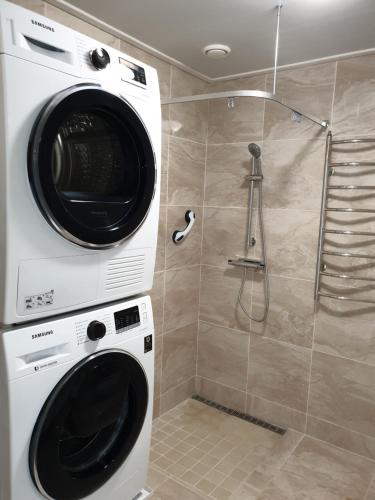 a washing machine in a bathroom with a shower at The old school motell & lägenheter in Marma