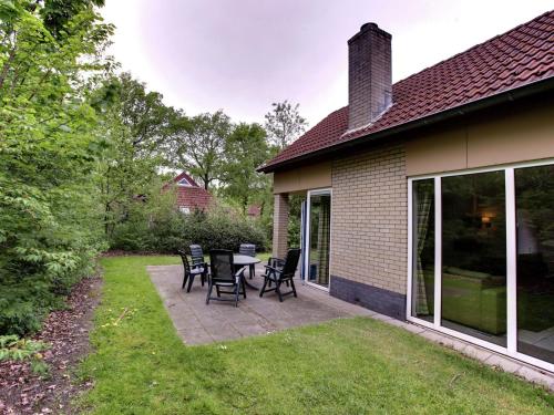 d'une cour avec des chaises et des tables. dans l'établissement Cozy holiday home with a garden near Zwolle, à Dalfsen