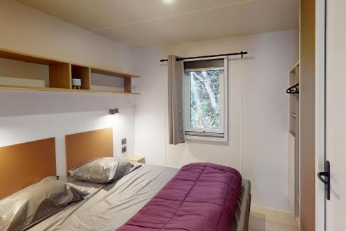 a bedroom with a bed and a window at CAMPING SAINT GABRIEL *** in Tarascon
