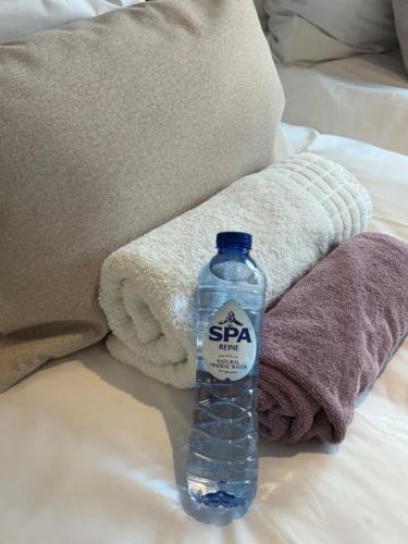 a bottle of water sitting on top of a bed at Studio de l'Avenue in Spa