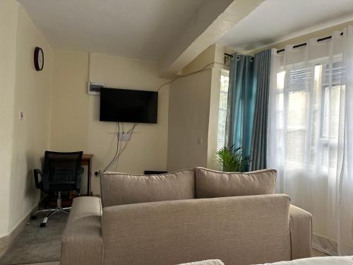 a living room with a couch and a flat screen tv at Amani Stays in Embu