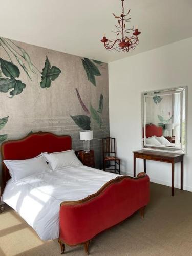 1 dormitorio con 1 cama grande y cabecero rojo en Demeure exceptionnelle proche du château de Vire, en Vire