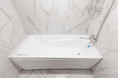 a white bath tub in a bathroom with marble walls at Отель KOKSHETAU in Kokshetau