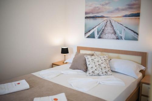 a bedroom with a bed with a picture on the wall at Guest House S-Lux in Petrovac na Moru