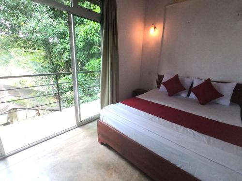 a bedroom with a bed and a large window at Kandy River Breeze in Kandy