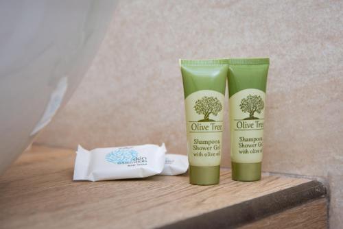 two bottles of olive tree products sitting on a table at Simeon Rooms & Apartments in Kamarai