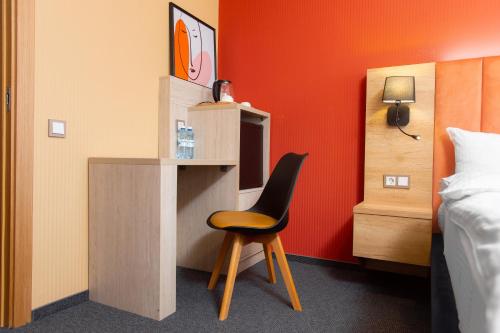 a room with a desk with a chair next to a bed at Отель KOKSHETAU in Kokshetau