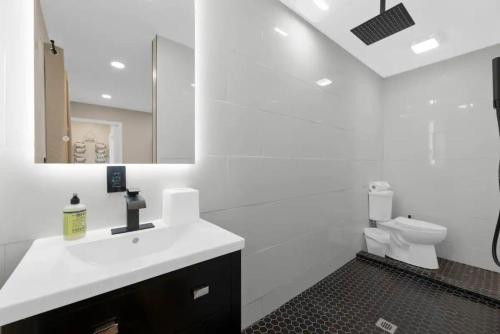 ein weißes Bad mit einem Waschbecken und einem WC in der Unterkunft Best Location Sleeps 12 Hot Tub Free Parking in Columbus