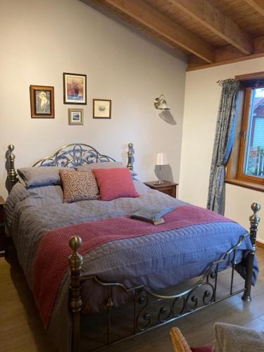a bedroom with a bed with pillows on it at Invercassley cottage in Lairg