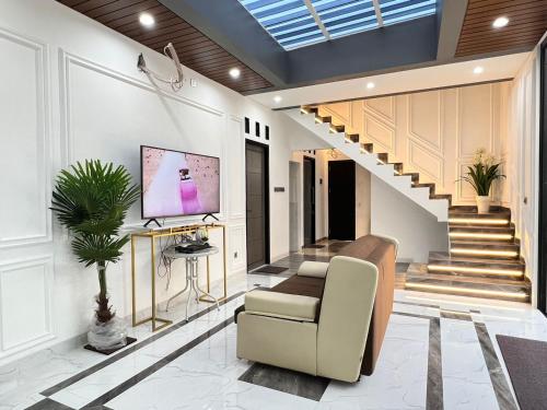 雅加達的住宿－Belle's WMR Guest House，客厅配有沙发和墙上的电视