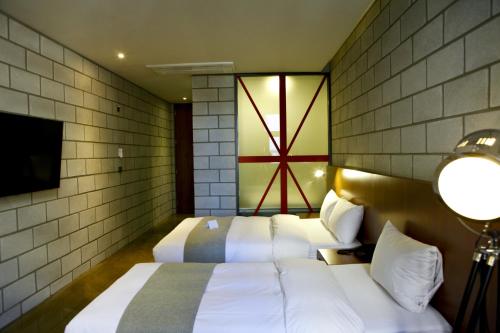 a bedroom with two beds and a window and a tv at Hotel Doma Myeongdong in Seoul
