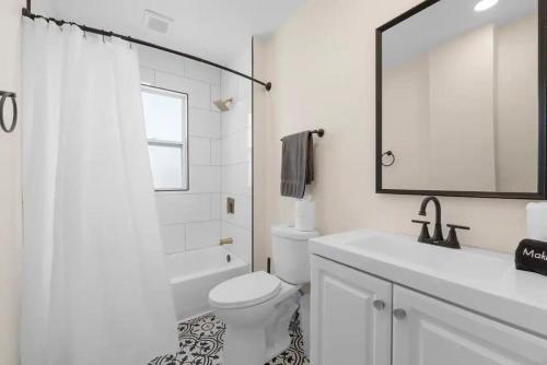 a bathroom with a toilet and a sink and a mirror at 5 Bedrooms Sleeps 14 - Hot Tub - 1 min to Fairgrounds in Columbus