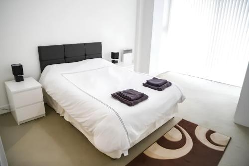 a bedroom with a white bed with two towels on it at Serviced Apartment In Liverpool City Centre - Free Parking - Balcony - by Happy Days in Liverpool