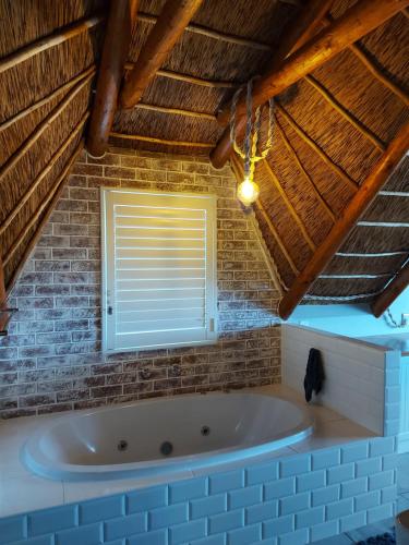 Cette chambre dispose d'une baignoire et d'une fenêtre. dans l'établissement Zeezicht Villa - Jacobsbaai, à Jacobs Bay