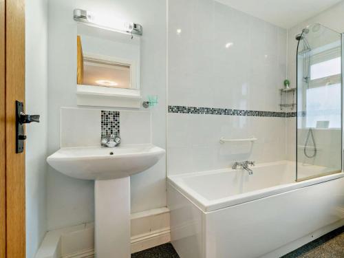 a white bathroom with a sink and a shower at 2 Bed in Lulworth 94448 in Winfrith Newburgh
