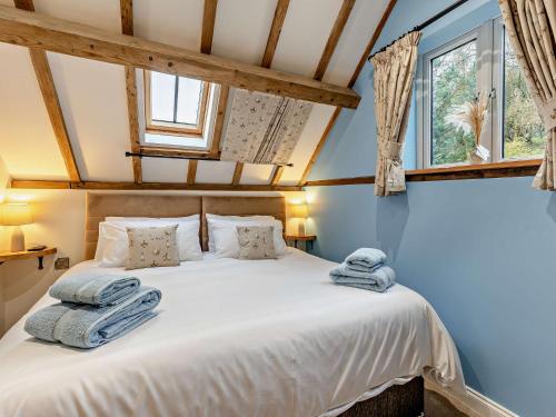 um quarto com uma cama branca e toalhas em 3 Bed in Bridgnorth 94532 