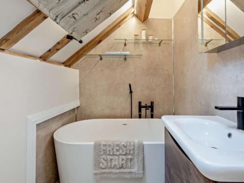 uma casa de banho com uma banheira branca e um lavatório. em 3 Bed in Bridgnorth 94532 