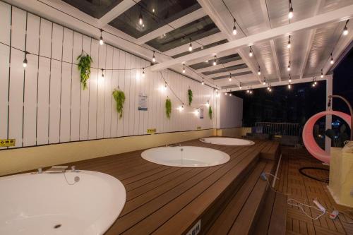 a bathroom with three sinks in a room at Ashare Hotel in Jiaoxi