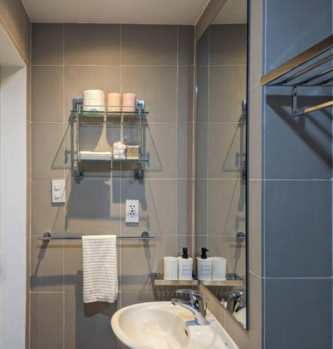 a bathroom with a sink and a mirror at Bright & Stylish Studio Condo in Commonwealth, UP Diliman in Manila