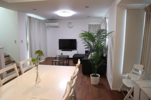 a living room with a white table and a tv at L＆L（Love＆Life） in Tokyo