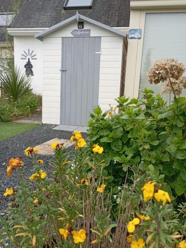 a garden with yellow flowers in front of a garage at Ty Sterenn e Giulia 700m de la plage de Lodonnec in Loctudy