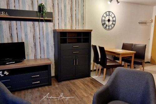 - un salon avec une armoire et une table avec des chaises dans l'établissement Haus-Koenigsduene-II-7, à Borkum