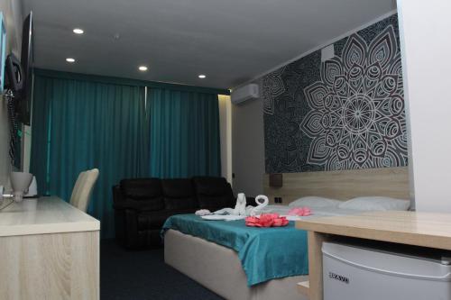 une chambre d'hôtel avec un lit et un canapé dans l'établissement Altyn Shatyr Hotel and Restaurant, à Aksay