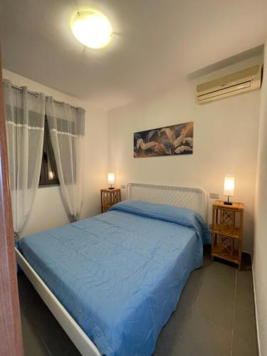 um quarto com uma cama azul e duas mesas de cabeceira em Casa Porto San Rocco em Marina di Grosseto