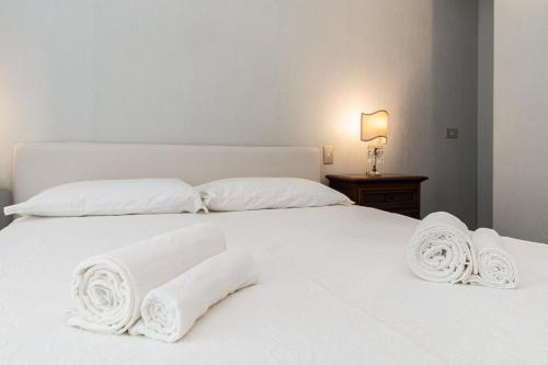 a white bed with white sheets and pillows at IMMOBIRENT - 5min spiagge - 15min centro città in Genoa