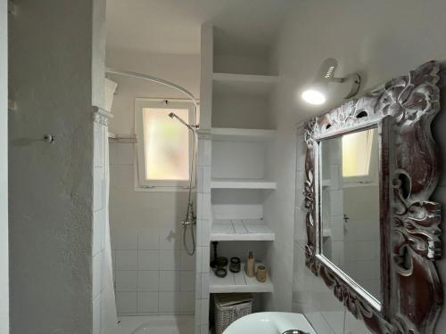 y baño con ducha y espejo. en KASSIOPEA, en Cala Blanca