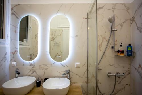 y baño con 2 lavabos y ducha. en Ourania by Heloni Apartments, en Atenas