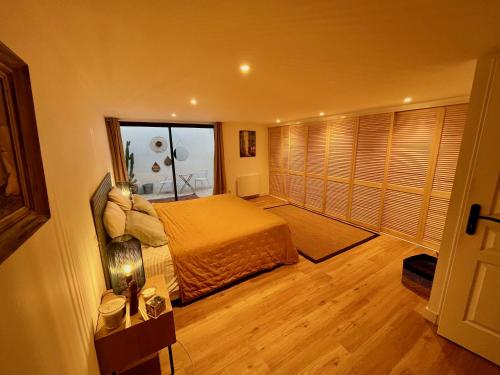 a bedroom with a bed and a large window at Villa dans son écrin de verdure in La Ciotat