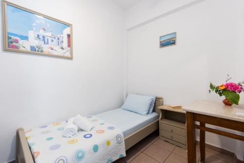 a small bedroom with a bed and a desk at Simeon Rooms & Apartments in Kamarai